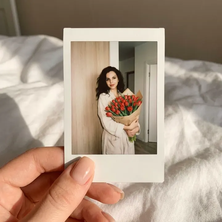 Рука с фото Instax и тюльпанами