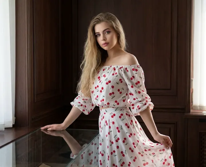 Женщина в белом костюме с вишнями