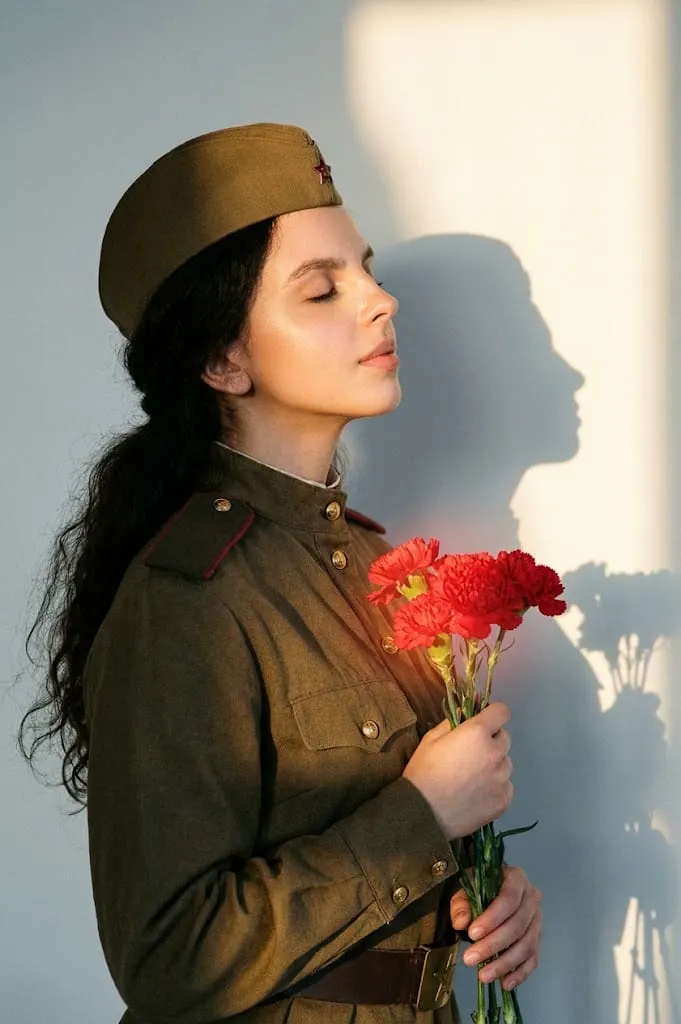 Женщина в военной форме с гвоздиками