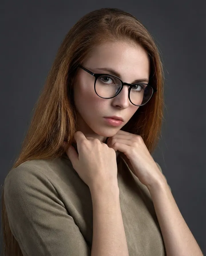 Студийный fashion-портрет девушки в очках на сером фоне