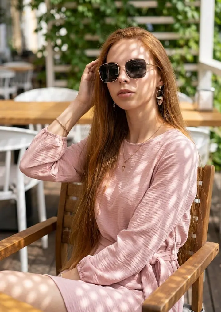 Женщина в розовом платье в кафе