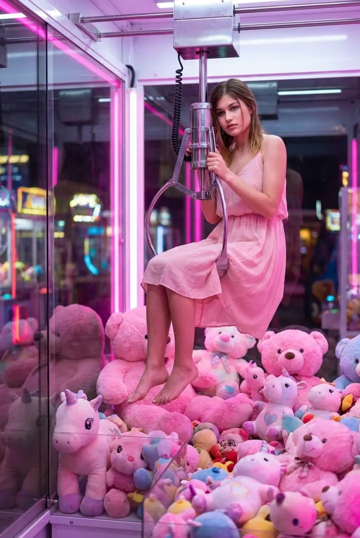 Женщина в розовом игровом автомате с игрушками