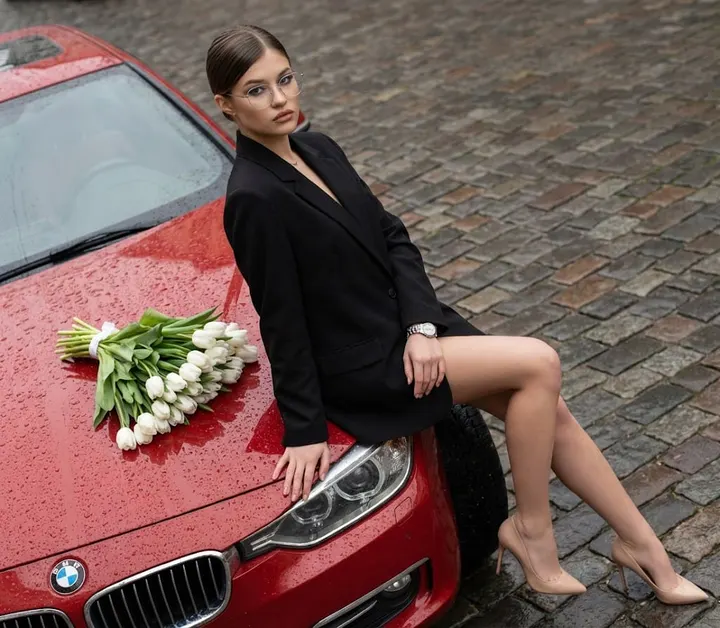 Девушка на красном BMW с тюльпанами