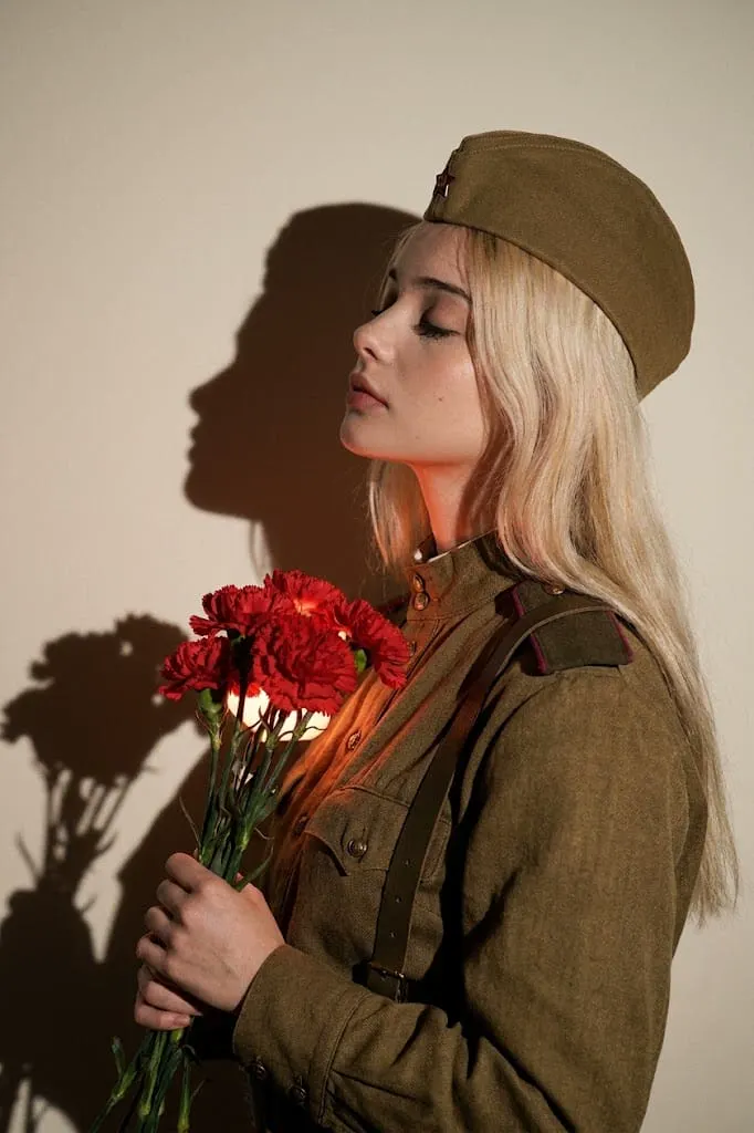 Женщина в военной форме с гвоздиками